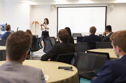 Professionals sitting in a classroom, looking toward the indstructor at the front