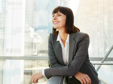 Happy professional looking out of an office window